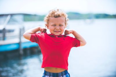Child posing with muscles and smiling