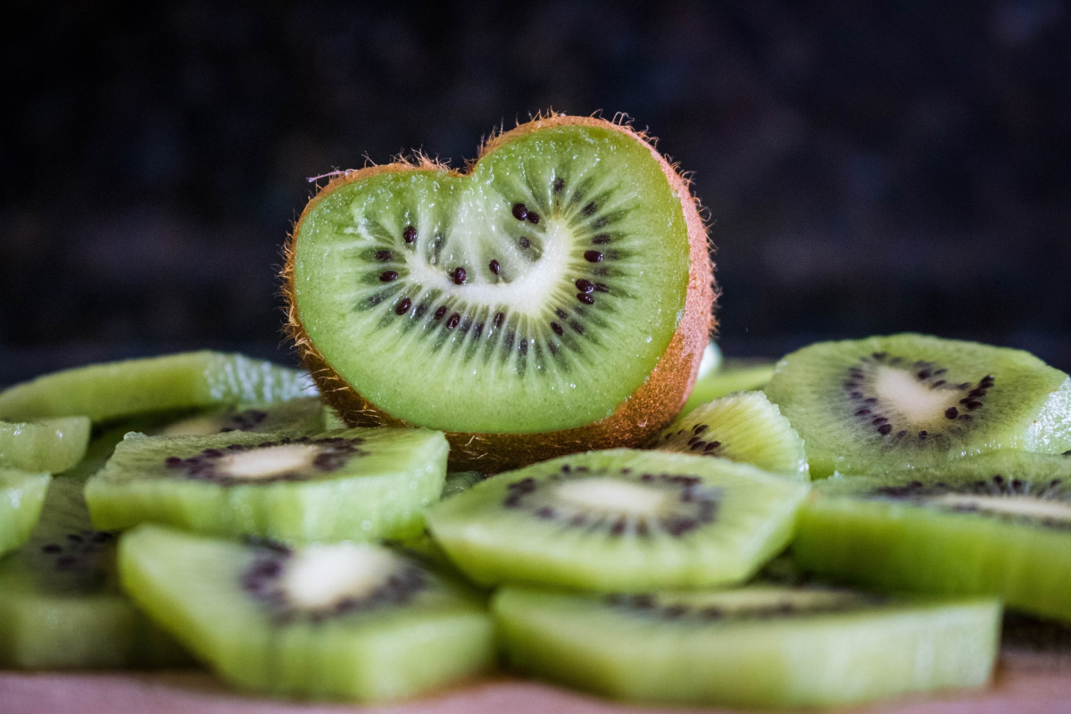 An array of kiwi fruits, one of them shaped like a heart. High cholesterol is a global health issue.