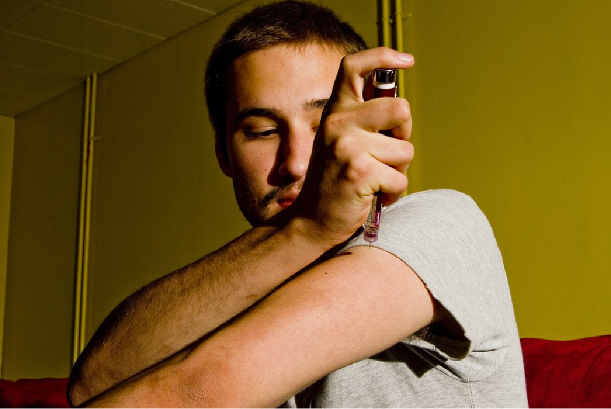 A young Caucasian man injecting insulin. Studies show a vegan diet can reduce the risk of developing type 2 diabetes.