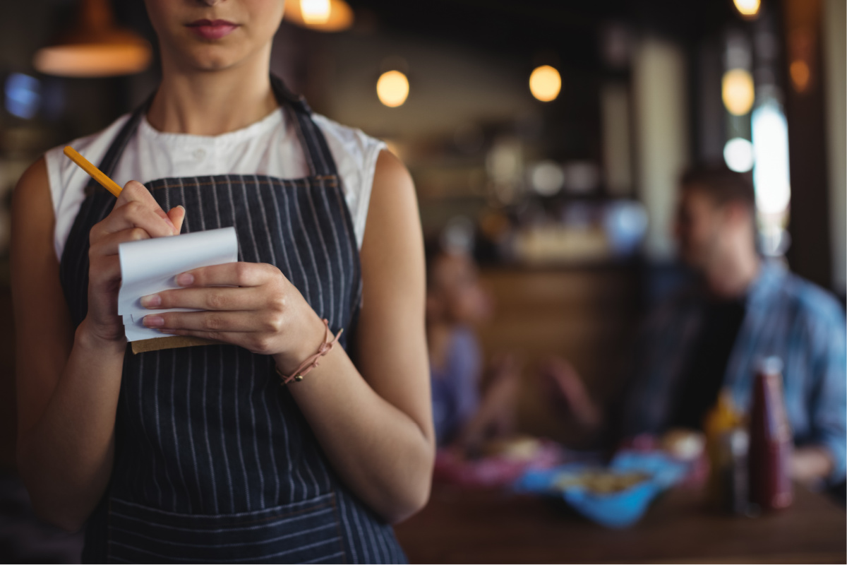 Unidentified waitress holding a notebook and pen to take someone's order