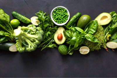 An array of green fruits and vegetables, sources of iron for vegans