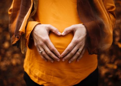Pregnant woman making a love heart shape