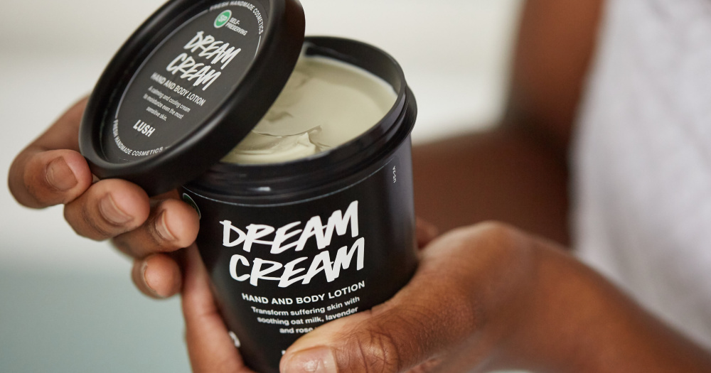 Unidentified person holding a tub of Lush Dream Cream hand and body lotion