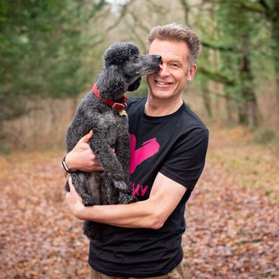 Chris Packham holding a dog smiling. Find out about us and our ambassadors. 