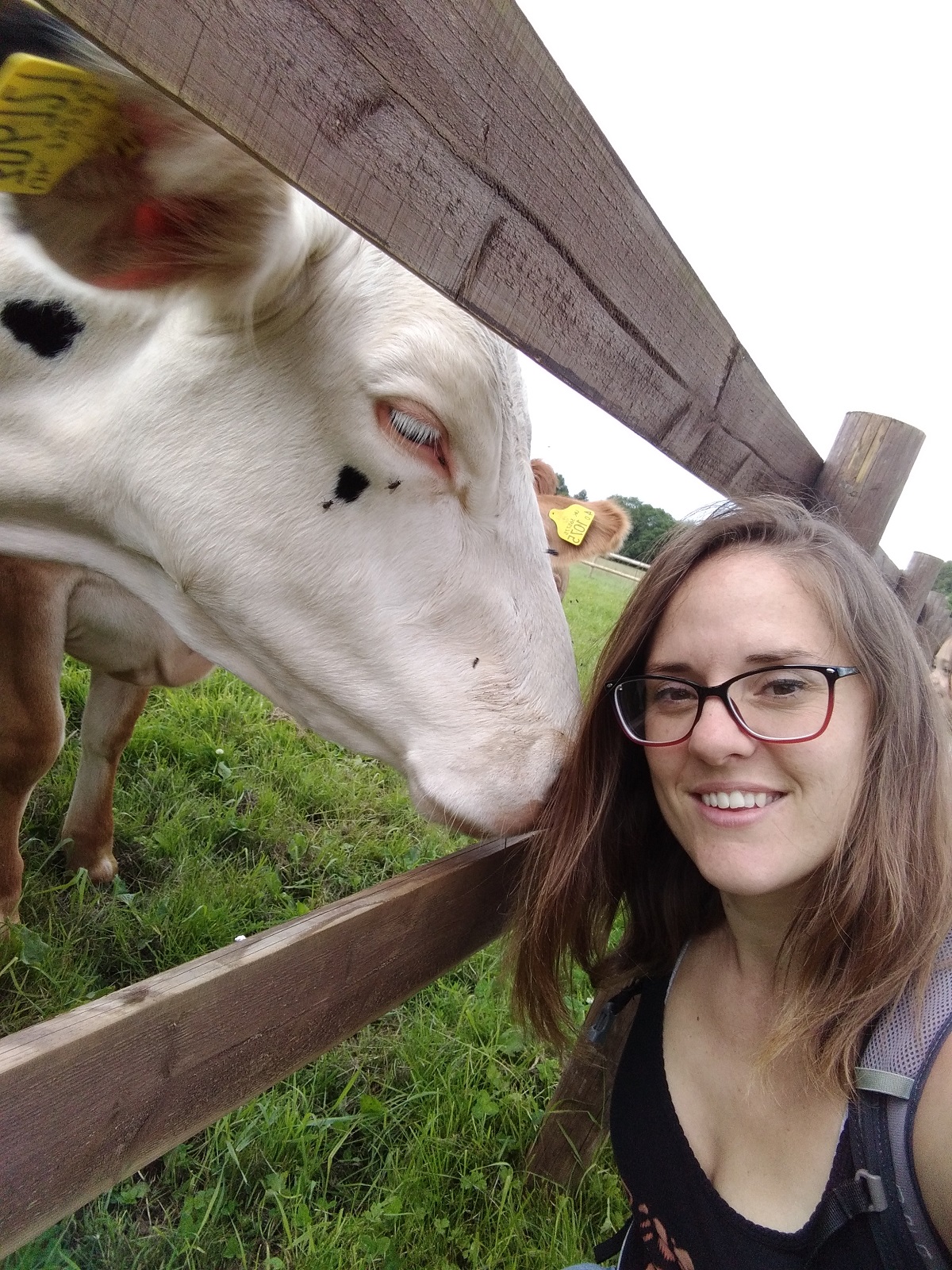 A young woman, Amy, in a field with a cow. Amy is one of the vegan mums we spoke to for this piece.