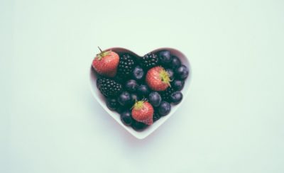 Frutas em uma tigela em formato de coração representam o veganismo no combate à pressão alta