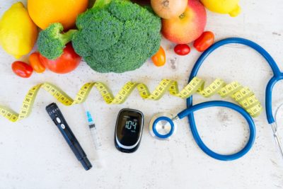 raw vegetables with blood glucose meter, syringe, lancet and stethoscope on desk, diabetes healthy diet concept