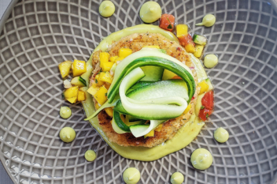 A vegan crab cake plated with tropical salsa