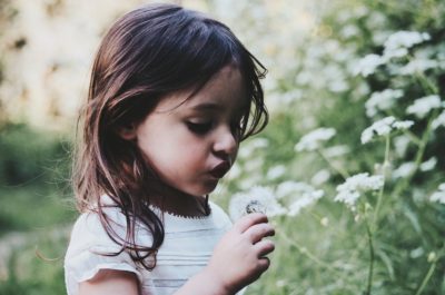 Child blowing flower
