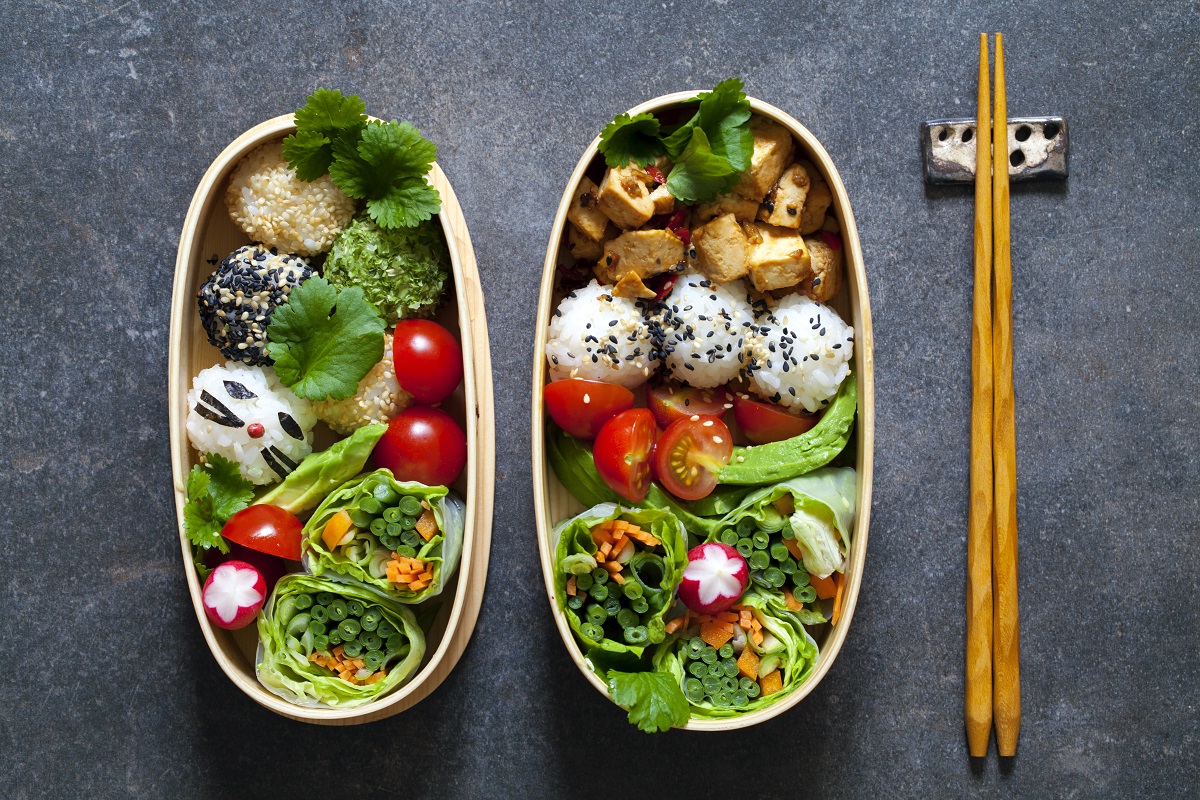 Colorful vegan bento lunch box with green vegetables and tofu