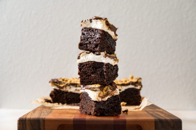 a stack of s'mores brownies topped with chocolate and graham cracker