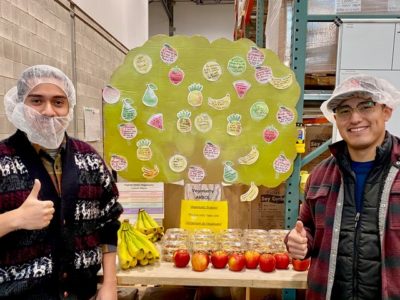 Two people stand in front of fresh produce