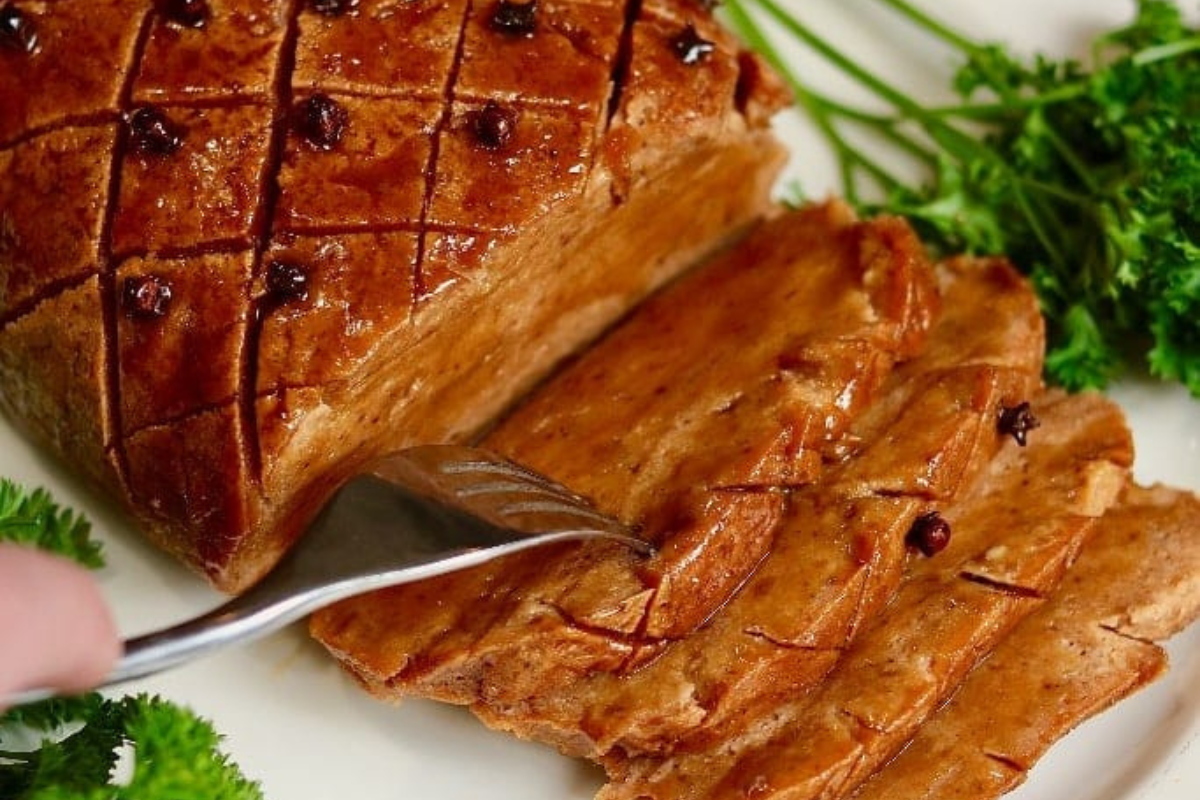 A close-up of a half sliced vegan ham