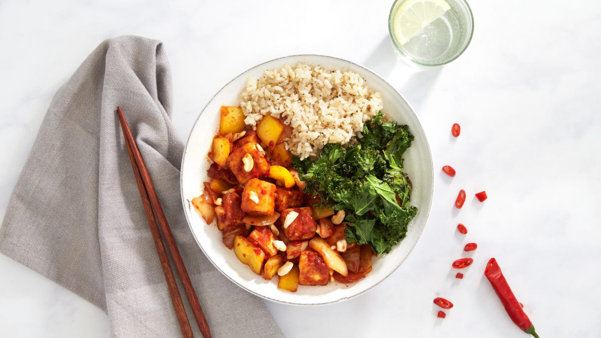 Sweet & sour sticky tofu marinade with rice and kale in a bowl