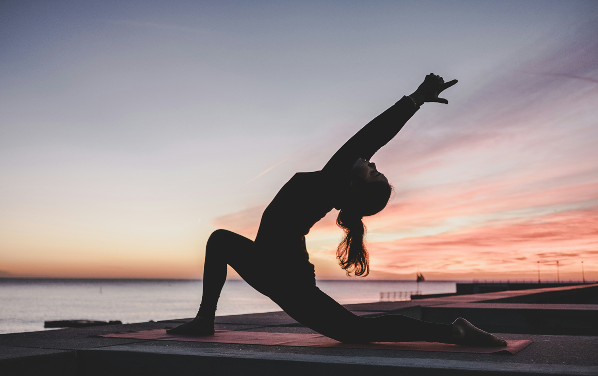 Woman doing yoga on the beach