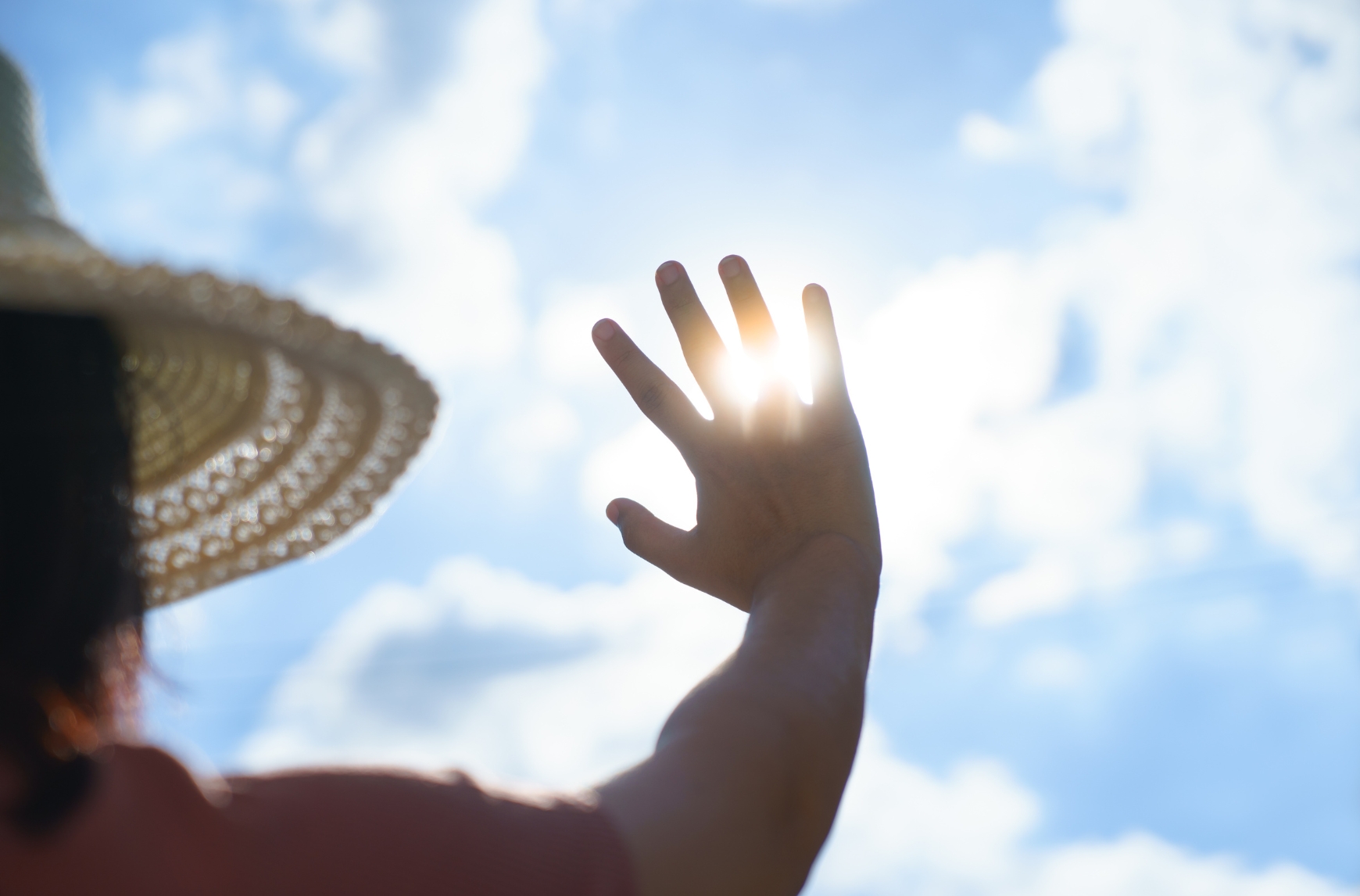 A person holds her hand against sunlight