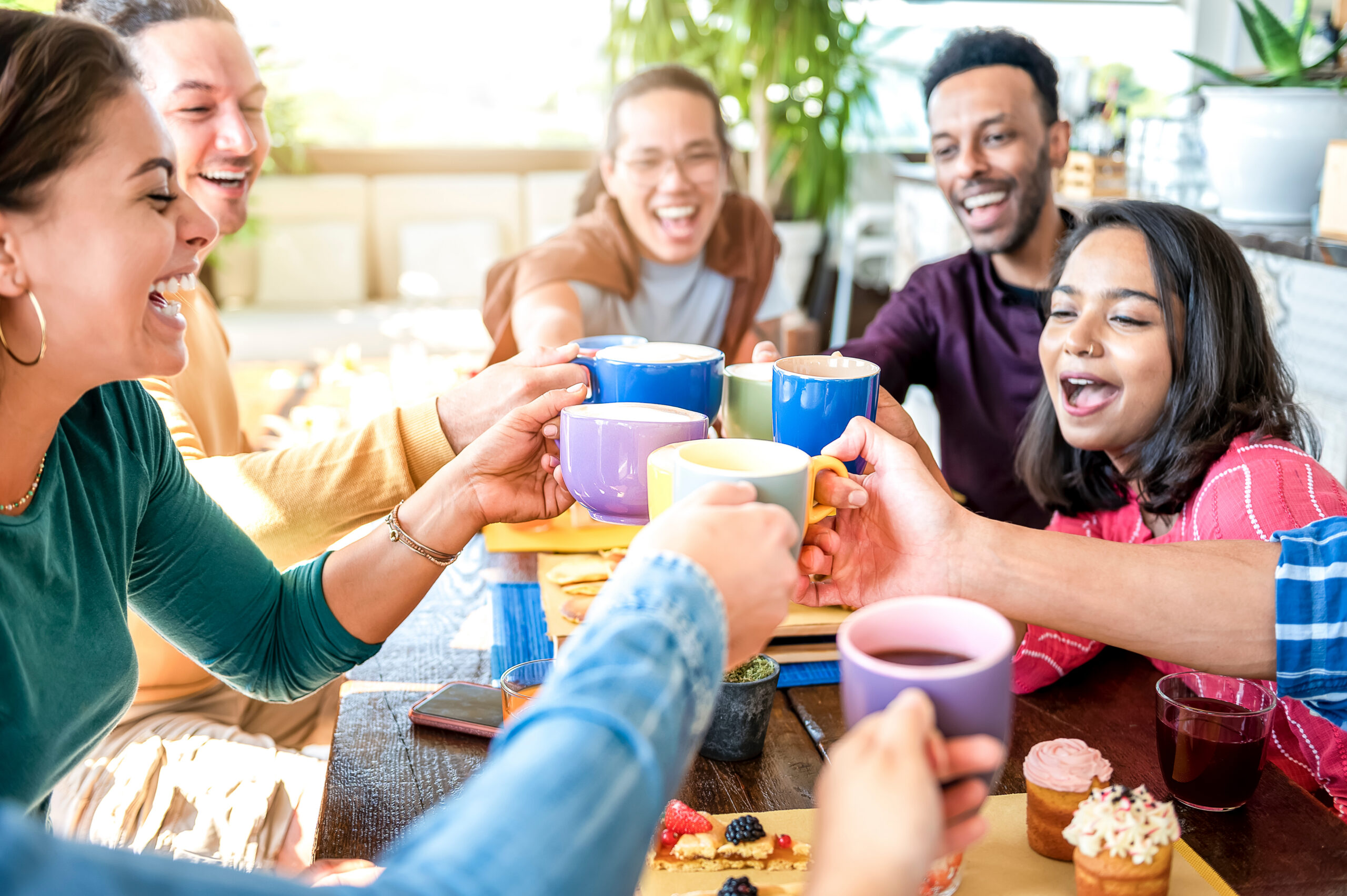 Friends sharing plant-based cake and coffee around a table